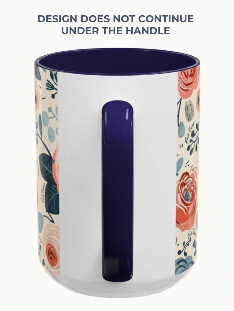 May include: White ceramic mug with a navy blue interior and handle. The mug features a floral design with red and peach roses, blue accents, and green leaves. The text "DESIGN DOES NOT CONTINUE UNDER THE HANDLE" is printed at the top.