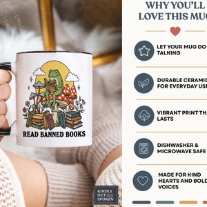 May include: White ceramic mug with a black handle and rim, featuring a whimsical design. The design includes a frog reading a book, mushrooms, and the text "READ BANNED BOOKS". The mug also has the text "WHY YOU'LL LOVE THIS MUG".