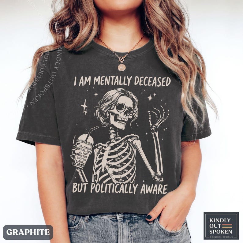 May include: A graphite-colored t-shirt featuring a graphic of a skeleton wearing sunglasses and holding a drink. The text reads I AM MENTALLY DECEASED BUT POLITICALLY AWARE. The drink cup has text that reads THE ECONOMY IS GONE AND ALL I GOT WAS THIS DECAYING DRINK.