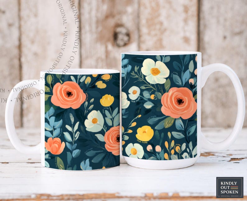 May include: Two white ceramic mugs featuring a dark navy blue background with a repeating floral pattern of peach, yellow, and cream-colored flowers, along with green and blue leaves. The mugs have a white handle and a white interior rim.