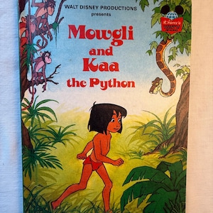 May include: A vintage children's book titled "Mowgli and Kaa the Python" by Walt Disney Productions. The cover features an illustration of Mowgli running, with a snake and monkeys. The book has a light blue background with green foliage.