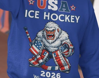 Sudadera de hockey sobre hielo de EE. UU. con cuello redondo para los Juegos de Invierno de 2026, Bigfoot Yeti, regalo patriótico para fanáticos del hockey