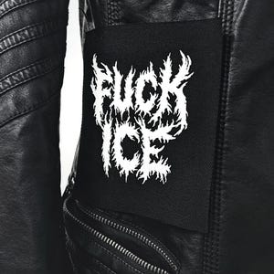 May include: Black leather jacket with a white "FUCK ICE" patch. The jacket has a zip and quilted shoulder detailing. The image is from oakthorn studios.
