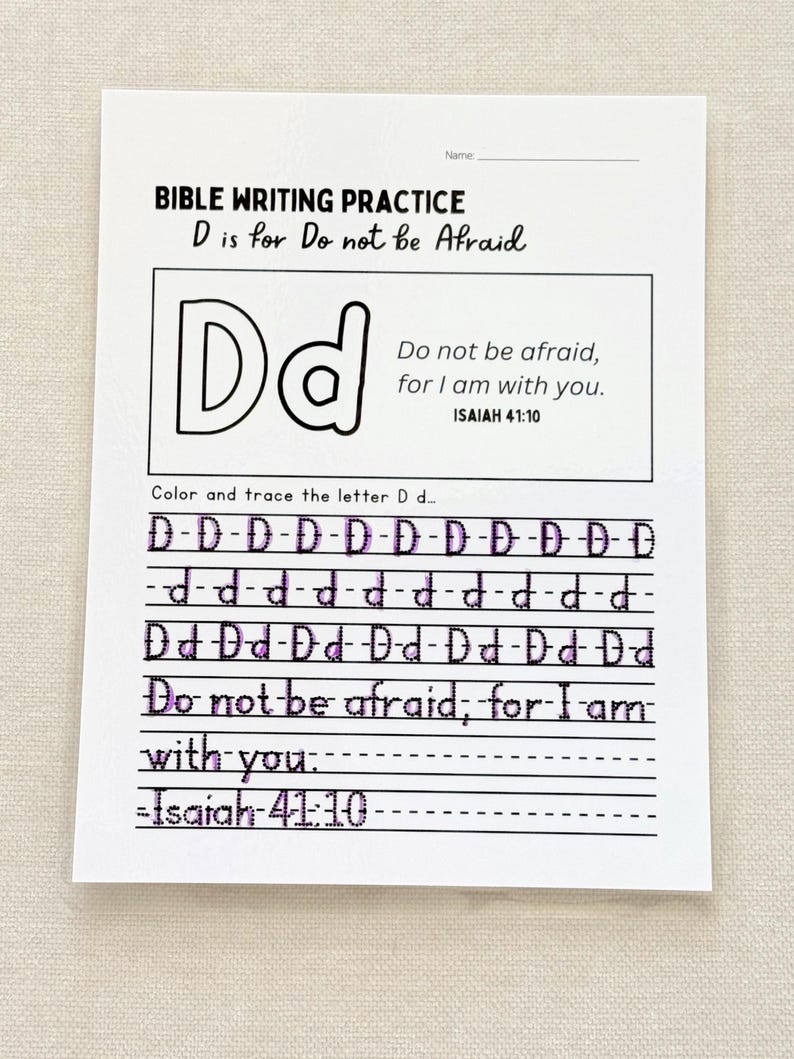 May include: A white Bible writing practice sheet with the text "BIBLE WRITING PRACTICE D is for Do not be Afraid". The sheet includes the letter D, the phrase "Do not be afraid, for I am with you", and the scripture reference Isaiah 41:10.
