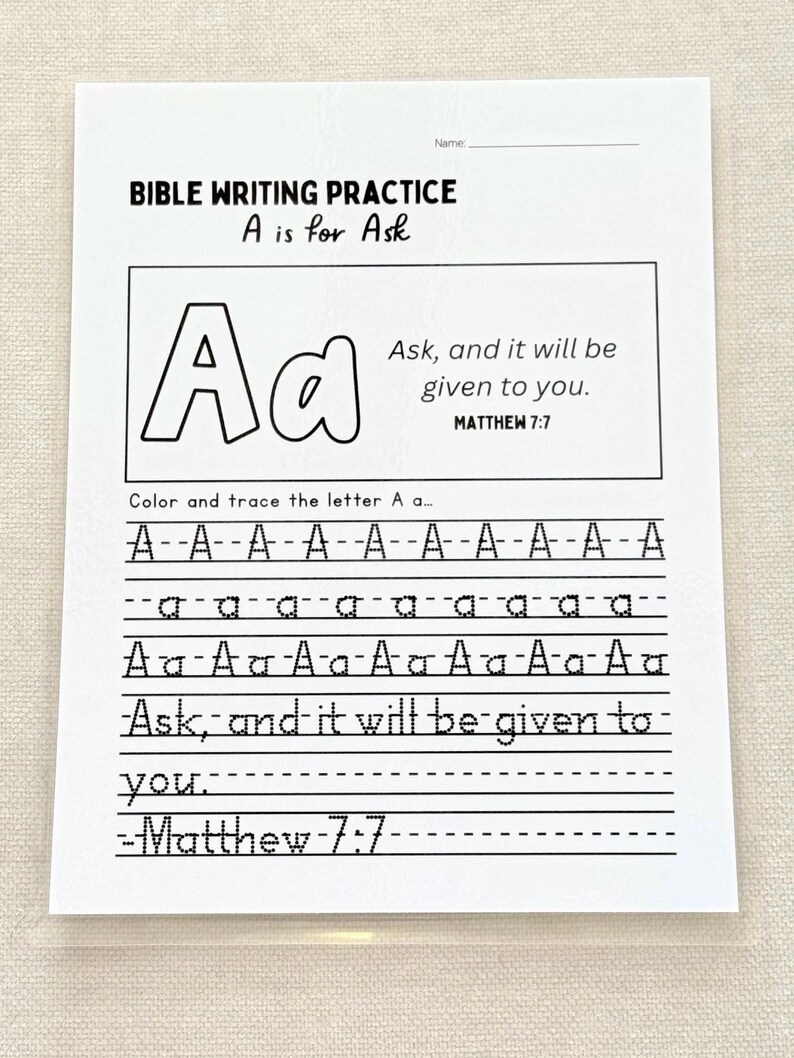 May include: A white Bible writing practice sheet with the text "BIBLE WRITING PRACTICE A is for Ask". The sheet includes the letter "A" in uppercase and lowercase, with lines for tracing and the Bible verse Matthew 7:7.