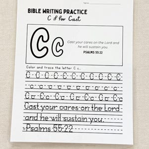 May include: A white Bible writing practice sheet with the text "BIBLE WRITING PRACTICE C if for Cast." The sheet includes the letter "C" in large and small forms, with the text "Cast your cares on the Lord and he will sustain you. Psalms 55:22."