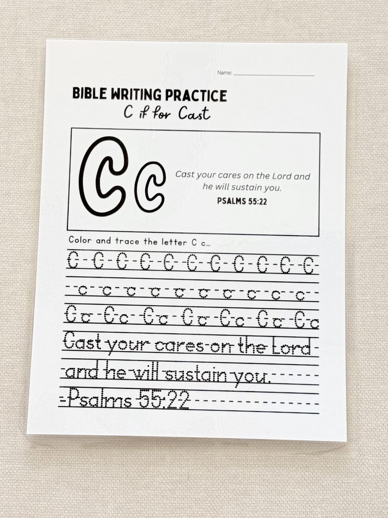 May include: A white Bible writing practice sheet with the text "BIBLE WRITING PRACTICE C if for Cast." The sheet includes the letter "C" in large and small forms, with the text "Cast your cares on the Lord and he will sustain you. Psalms 55:22."
