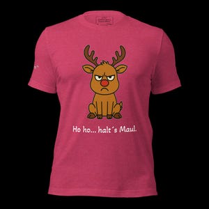 K&ouml;nnte beinhalten: Ein pinkfarbenes T-Shirt mit einem Cartoon-Rentier mit w&uuml;tendem Gesicht und roter Nase. Das Rentier hat braunes Geweih und sitzt. Unter dem Rentier steht der Text "Ho ho... halt's Maul."