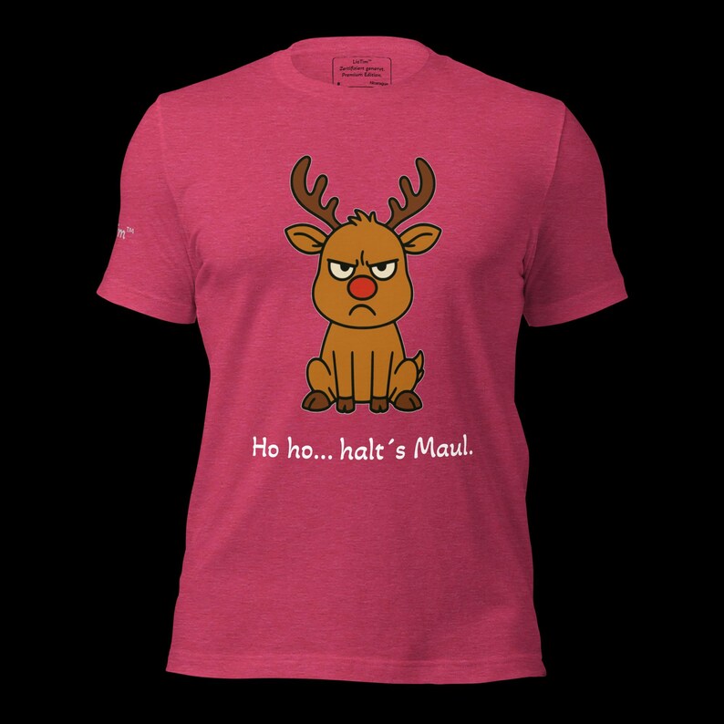 K&ouml;nnte beinhalten: Ein pinkfarbenes T-Shirt mit einem Cartoon-Rentier mit w&uuml;tendem Gesicht und roter Nase. Das Rentier hat braunes Geweih und sitzt. Unter dem Rentier steht der Text "Ho ho... halt's Maul."