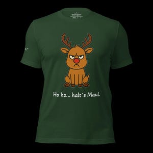 K&ouml;nnte beinhalten: Dunkelgr&uuml;nes T-Shirt mit einem Cartoon-Rentier mit w&uuml;tendem Gesicht und roter Nase. Das Rentier hat braunes Geweih und sitzt. Der Text "Ho ho... halt's Maul" ist unter dem Rentier aufgedruckt.