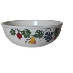 May include: White ceramic bowl with a decorative fruit and vine design. The bowl features illustrations of red berries, green leaves, yellow pears, and purple grapes. A kitchenware item.
