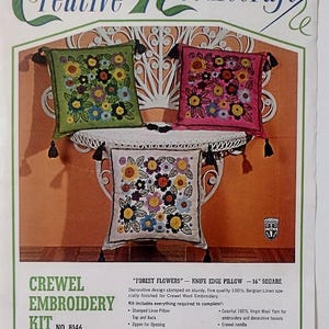May include: A Bucilla Creative Needlecraft kit for a "Forest Flowers" crewel embroidery decorator pillow. The kit includes a stamped linen pillow, wool yarn, and a needle. The finished pillow will be 16 inches square and feature a floral design.