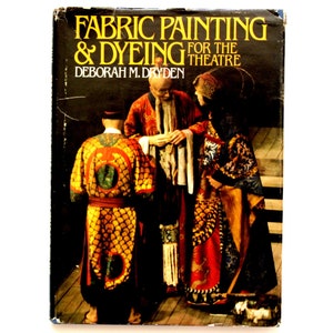 May include: Book cover with the title "Fabric Painting & Dyeing for the Theatre" by Deborah M. Dryden. The cover features a photo of three people wearing colorful, patterned robes.