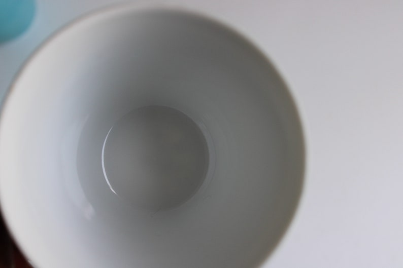 Pu&ograve; includere: Una tazza in ceramica bianca con una finitura liscia e lucida. L'interno della tazza &egrave; vuoto.