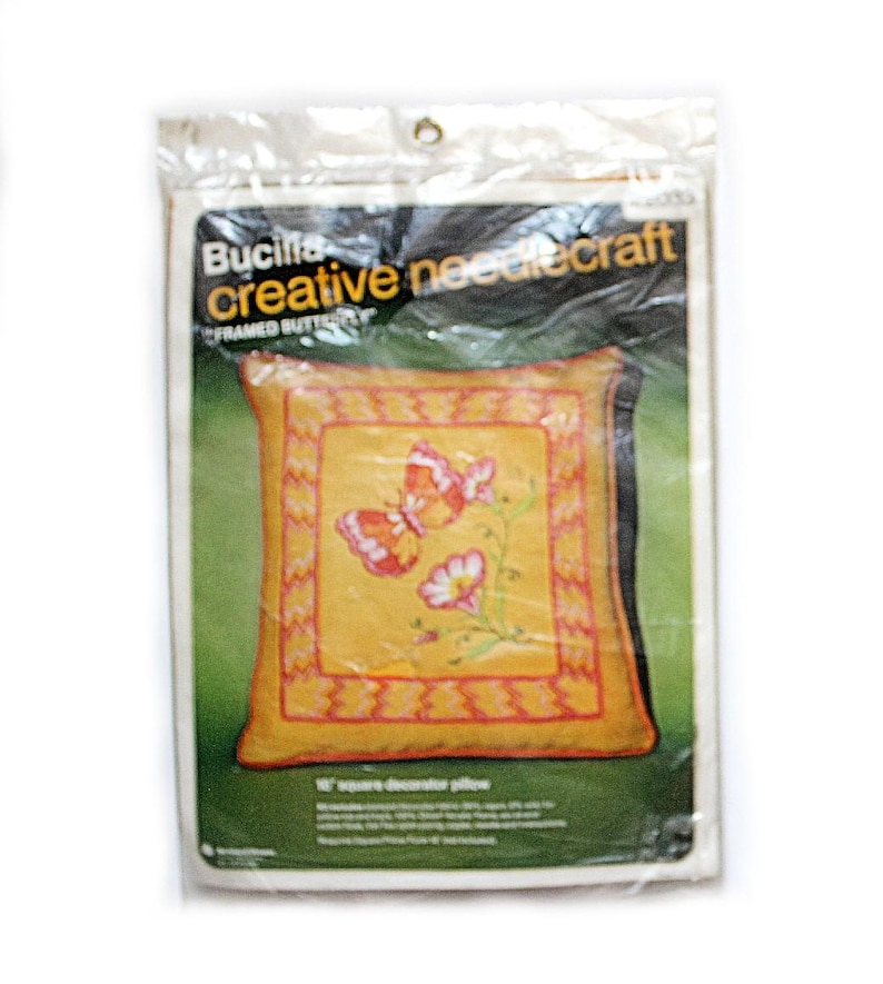 May include: A Bucilla creative needlecraft kit for a framed butterfly pillow. The pillow design features a yellow background with a butterfly and floral design. The pillow is 16" square.