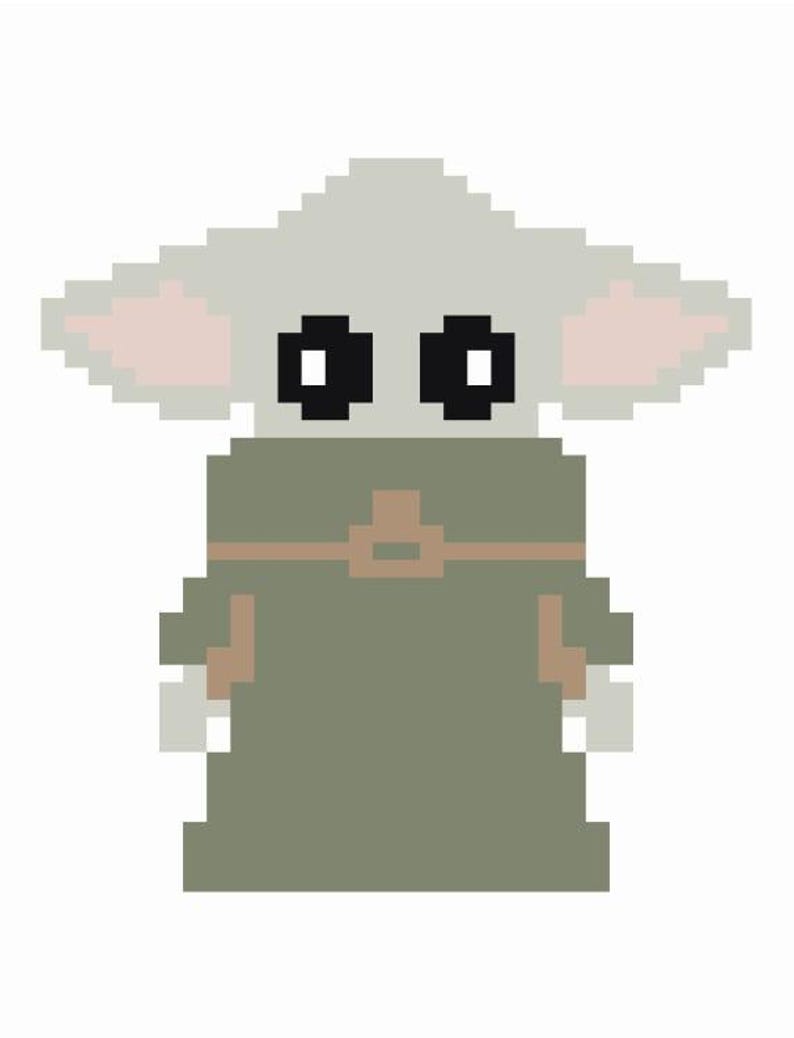 May include: Pixelated image of a character from The Mandalorian. The character has large black eyes, large ears with pink inner ears, and is wearing a green cloak with a brown strap. The background is white.