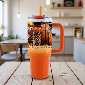 May include: An orange basketball-themed tumbler with a handle and straw. The tumbler features a collage of basketball images and the word "Basketball" in a stylized font. The tumbler is designed for cold beverages and is suitable for sports enthusiasts.