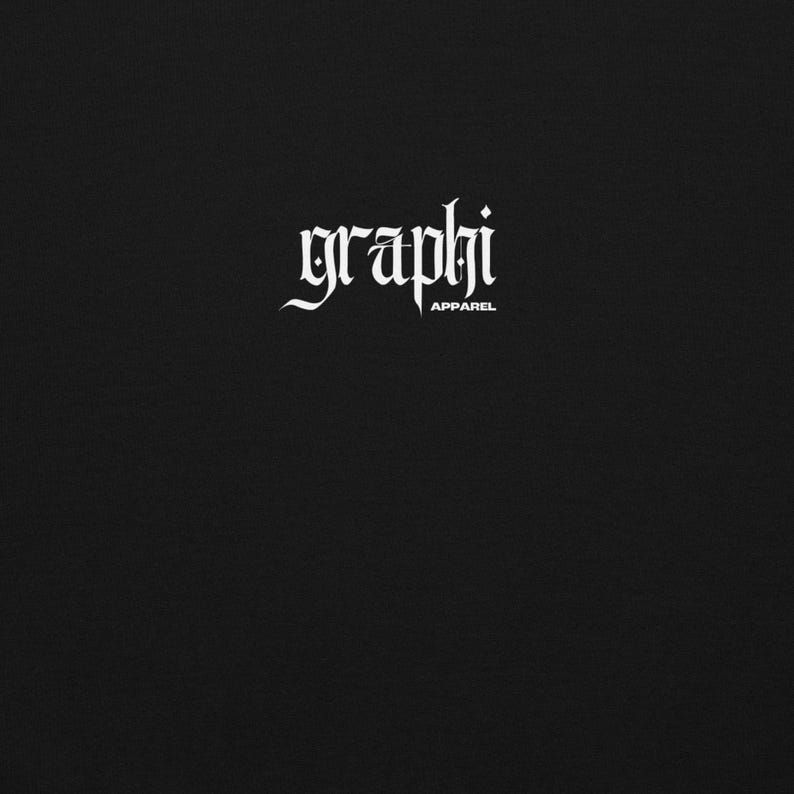 K&ouml;nnte beinhalten: Schwarzer Hintergrund mit dem wei&szlig;en Text "graphi" in einer gotischen Schriftart, darunter "APPAREL". Das Design ist zentriert und nimmt einen kleinen Teil des Bildes ein.