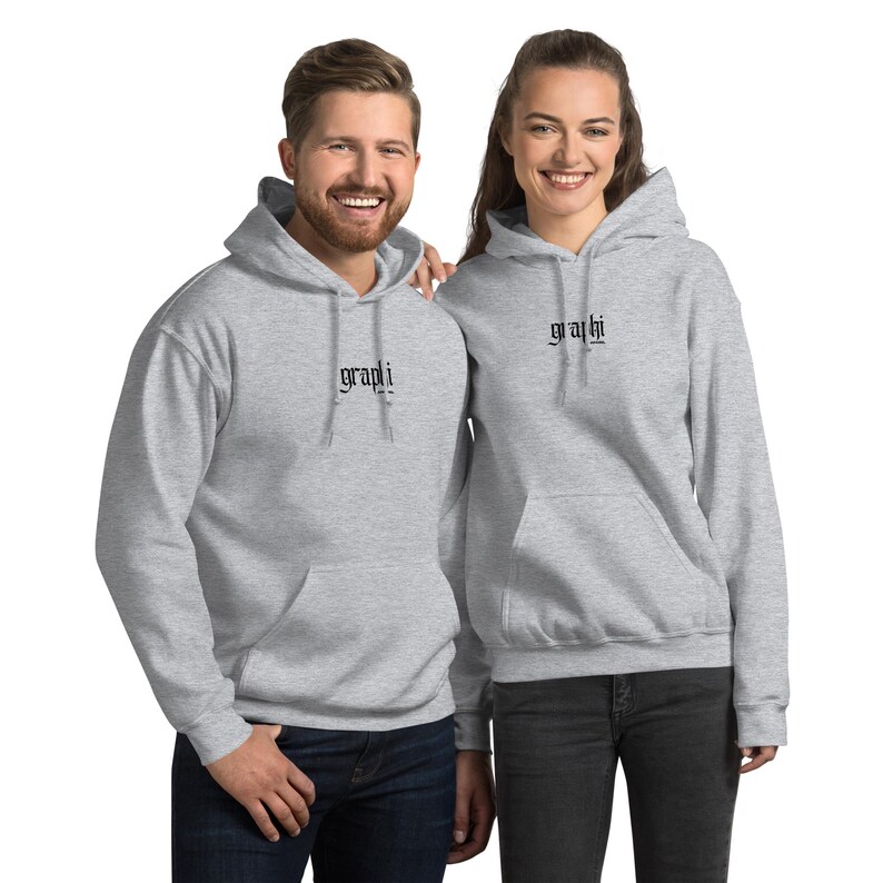 May include: Two individuals wearing matching light grey hoodies. Each hoodie features the word "graphi" in black script on the chest. The hoodies have a drawstring hood and a front pocket.