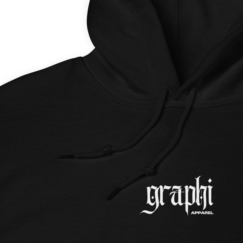K&ouml;nnte beinhalten: Schwarzer Kapuzenpullover mit wei&szlig;em Kordelzug und dem Wort "graphi" in gotischer Schrift. Das Wort "apparel" steht unter dem Wort "graphi". Der Pullover hat eine Vordertasche und eine Kapuze.