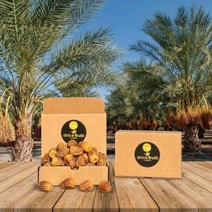 May include: A cardboard box filled with brown dried dates and a closed cardboard box next to it. Both boxes feature a circular black label with the text dolce frutti. The dates are oval-shaped and light brown, with several scattered on the surface.