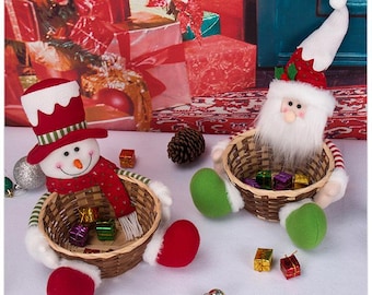Peut inclure: Deux paniers décoratifs de fête avec des figurines en peluche d'un bonhomme de neige et du Père Noël. Le bonhomme de neige porte un haut-de-forme et une écharpe rouges, tandis que le Père Noël porte un bonnet rouge à bordure blanche.