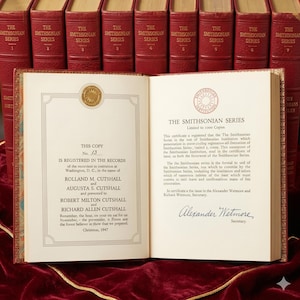 Op de afbeelding: Een open boek uit The Smithsonian Series met rode kaften en gouden letters. De linkerpagina toont registratiegegevens voor Rolland en Augusta Cutshall, terwijl de rechterpagina een certificaat van uitgifte en de handtekening van Alexander Wetmore bevat.