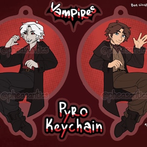 May include: A red and black Pyro Keychain featuring two cartoon vampire characters. The front shows a vampire with white hair and the back shows a vampire with brown hair. The keychain is 8.89 cm in height.