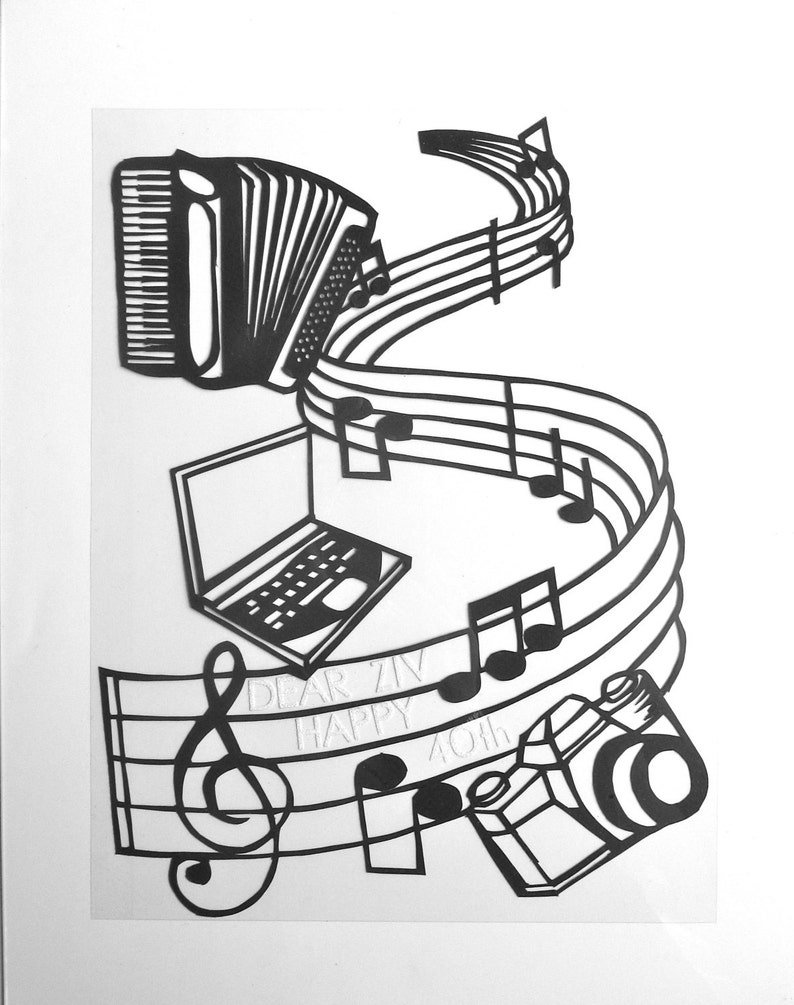 May include: Black and white paper cut-out art depicting a musical staff with notes, an accordion, a laptop, a camera, and a treble clef. The text "Dear Ziv Happy 40th" is written on the staff.