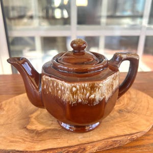 May include: A set of three ceramic mugs with a speckled, matte finish. The mugs are in shades of cream, light gray, and dark gray. Each mug has a simple, minimalist design, perfect for coffee or tea.