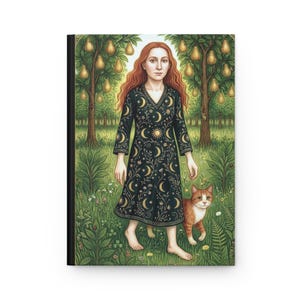 May include: A hardcover journal featuring a whimsical illustration. The artwork depicts a woman with red hair in a black dress adorned with moons and stars, standing in a garden with a cat. Pear trees are in the background.