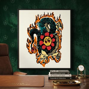 Puede incluir: Una impresión artística enmarcada que presenta una ilustración estilizada de una serpiente y una flor. La serpiente es negra y verde azulado, rodeada de llamas naranjas. La flor es roja con una cara amarilla. La obra está sobre un fondo crema.