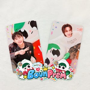 May include: Two rectangular photo cards featuring individuals posing with a cartoon character. Below the cards is a colorful sticker graphic with the text BounPrem and Paody, surrounded by illustrations of lollipops, hearts, and stars.