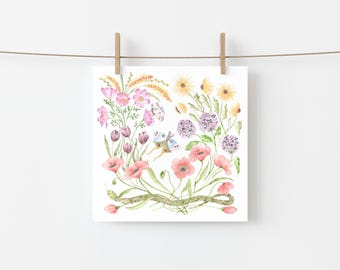 May include: Watercolor print of various flowers, including pink poppies, purple alliums, and yellow daisies, with butterflies and a green snake. The artwork is square and hangs from a clothesline with wooden clips.