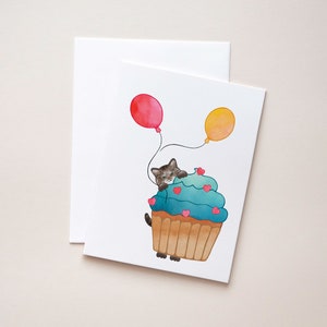 Brown Tabby Cat, Birthday Card - Show some love with a sweet Tabby Cat peeking out from behind a cupcake holding balloons.