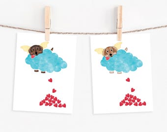 May include: Two illustrated cards with a dachshund dog wearing angel wings and holding a heart. The dog is on a blue cloud with red hearts falling from the cloud.