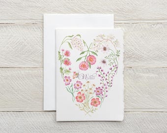 May include: A white card with a watercolor illustration of pink and white flowers arranged in a heart shape. The text "My Sister" is written in cursive in the center of the heart.