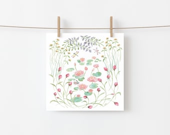 May include: Watercolor print of a serene pond scene with pink water lilies, green lily pads, and dragonflies. The artwork is framed by tall green grasses, yellow flowers, and purple lavender. The print is hanging from a clothesline with wooden clips.