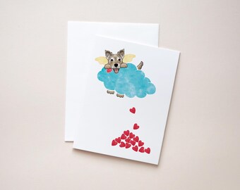 May include: A greeting card featuring a cartoon dog with angel wings holding a heart, flying in a blue cloud and dropping red hearts.