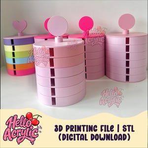 May include: A collection of cylindrical multi-tiered storage organizers in various colors including light pink, purple, yellow, green, blue, and orange. Each unit features a circular or heart-shaped topper and vertical slots. Text reads 3D PRINTING FILE | STL (DIGITAL DOWNLOAD).