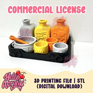 May include: A black tray with construction vehicle motifs holds a gray pot with an orange wrench, a yellow bottle with a dump truck, an orange bottle with a cement mixer, and three small cylindrical containers in yellow, orange, and gray colors.