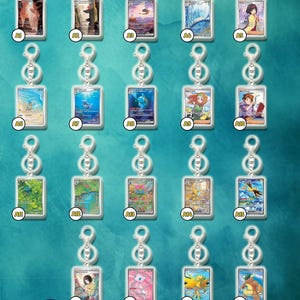 May include: Collection of keychains featuring various artwork, each with a silver-colored clasp. The keychains showcase different images, including landscapes, characters, and abstract designs. The EvoVault Shop logo is visible at the bottom.