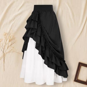 May include: A two-toned skirt featuring a black ruffled overlay over a white underskirt. The skirt has a high, elasticized waistband and a layered, asymmetrical design. The fabric appears to be lightweight and flowing.