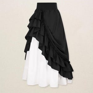 May include: A two-tone skirt featuring a black ruffled overlay and a white underskirt. The skirt has a high, elasticized waistband and a layered, asymmetrical design. The black fabric drapes elegantly, creating a flowing silhouette.