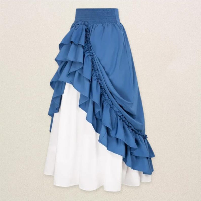 May include: A two-tone skirt featuring a blue ruffled overlay and a white underlayer. The skirt has a high, elasticized waistband and a cascading ruffle design that adds a dramatic flair. The skirt is made of a lightweight fabric.