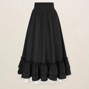 May include: A long, black skirt with a high waist and a layered, ruffled hem. The skirt has a flowing silhouette and a white lining that peeks out from the bottom. The skirt is made of a soft, draping fabric.