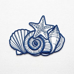 May include: A blue and white embroidered patch featuring a starfish and seashells. The design includes a five-pointed starfish atop a spiral shell, with a fan-shaped shell on the left and a conch shell on the right. The patch is on a white background.