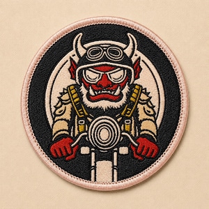 May include: Embroidered patch featuring a red demon riding a motorcycle. The patch has a black background with a white circular design behind the demon. The demon wears a helmet and sunglasses. The patch is outlined in pink.