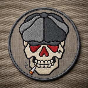 May include: A white ceramic mug with a black handle and the text "But First, Coffee" in a bold, black font. The mug is set against a blurred background, suggesting a cozy setting.