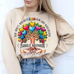May include: Beige sweatshirt with a colorful family tree design. The tree's leaves are heart-shaped in various colors. Text includes "OUR ROOTS RUN DEEP," "OUR LOVE RUNS DEEPER," "FAMILY REUNION 2026," and "JOHNSON."